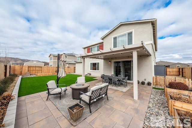 back of property with a patio area, a yard, and an outdoor living space with a fire pit