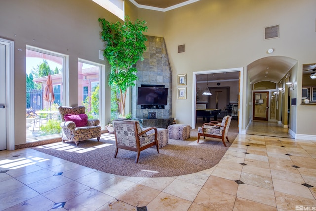 living room featuring light tile patterned floors, a towering ceiling, and crown molding