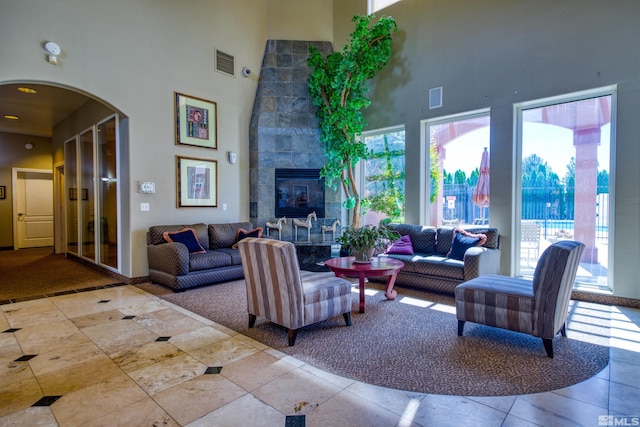 tiled living room with a towering ceiling and a tile fireplace