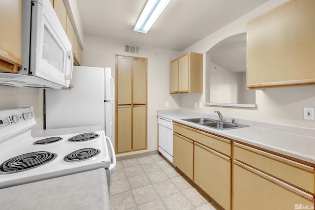 kitchen featuring light brown cabinets, white appliances, and sink