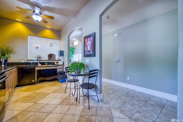 kitchen with ceiling fan with notable chandelier, sink, light tile patterned floors, and black dishwasher