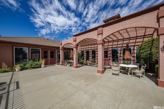 rear view of property featuring a pergola and a patio