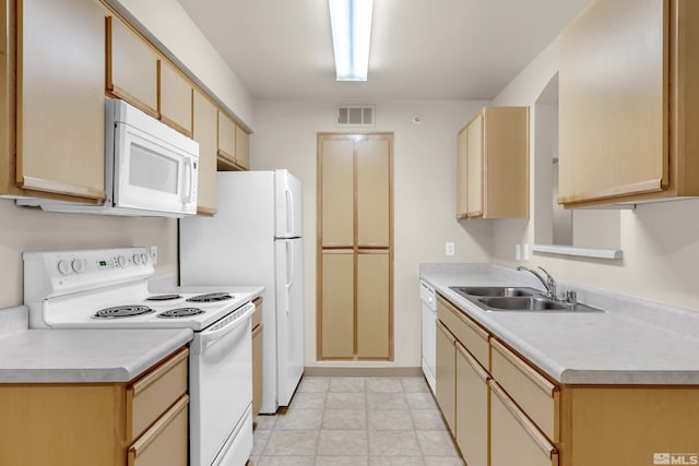 kitchen featuring light brown cabinets, white appliances, and sink