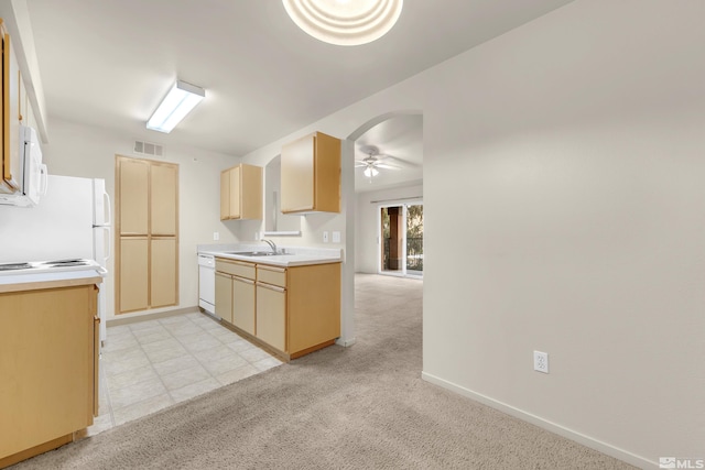 kitchen featuring ceiling fan, sink, light colored carpet, white appliances, and light brown cabinetry