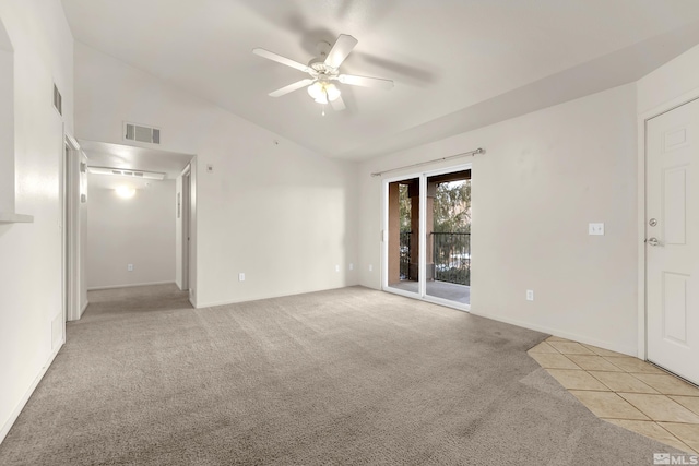 carpeted spare room featuring ceiling fan and vaulted ceiling