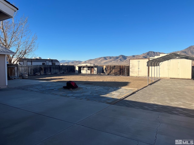 view of patio / terrace with a mountain view and a shed