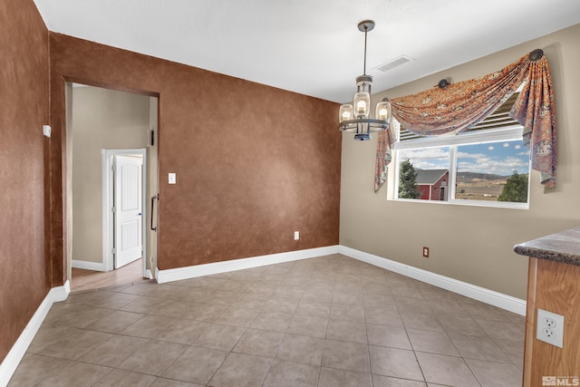 unfurnished dining area featuring a chandelier and tile patterned flooring