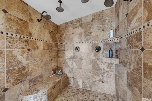 bathroom with a tile shower and a textured ceiling