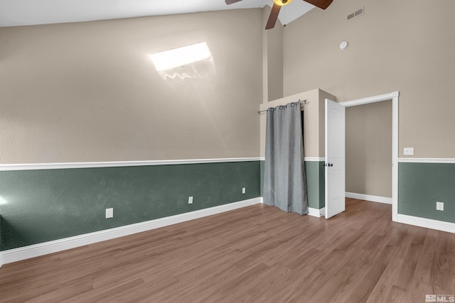 unfurnished room with ceiling fan, wood-type flooring, and lofted ceiling