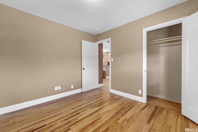 unfurnished bedroom featuring a closet and light wood-type flooring