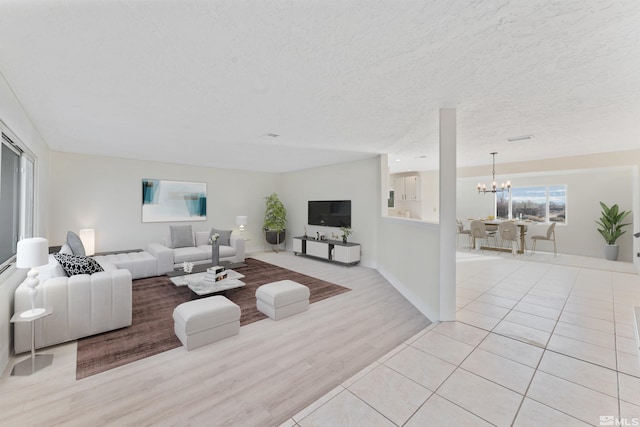 tiled living room featuring a textured ceiling and a notable chandelier