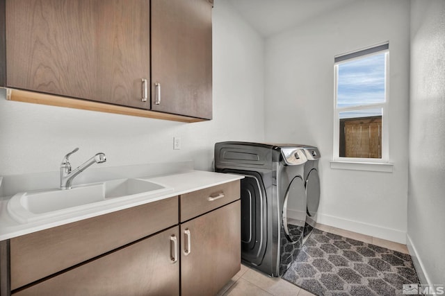 laundry area with washing machine and dryer, sink, light tile patterned flooring, and cabinets