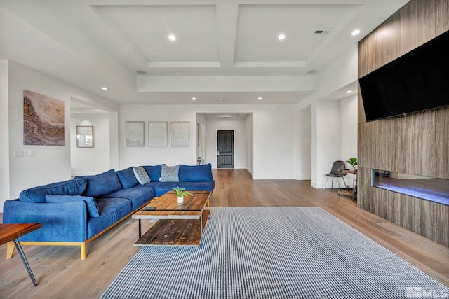 living room with a large fireplace and light hardwood / wood-style flooring