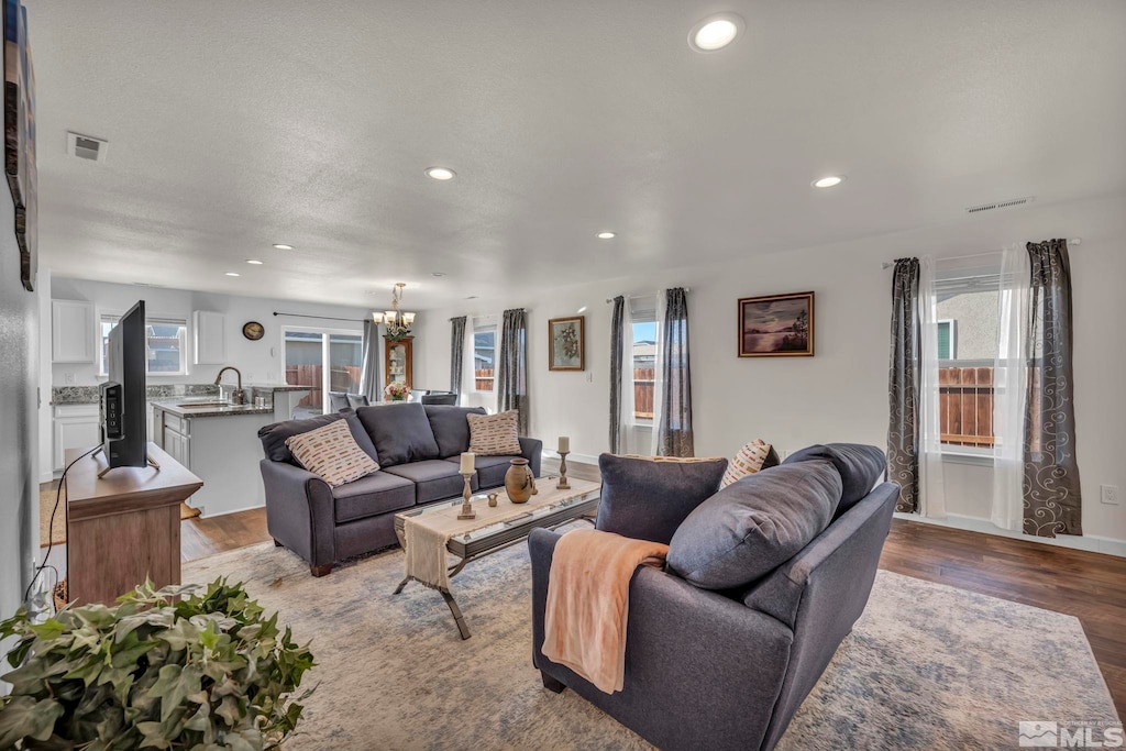 living room with sink, a healthy amount of sunlight, and light hardwood / wood-style floors