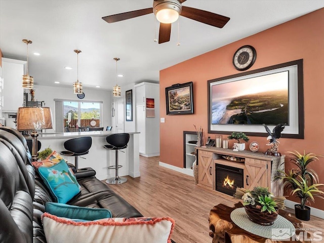 living room featuring ceiling fan and light wood-type flooring