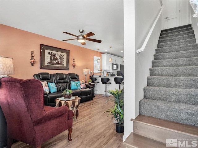 living room featuring ceiling fan and light hardwood / wood-style floors