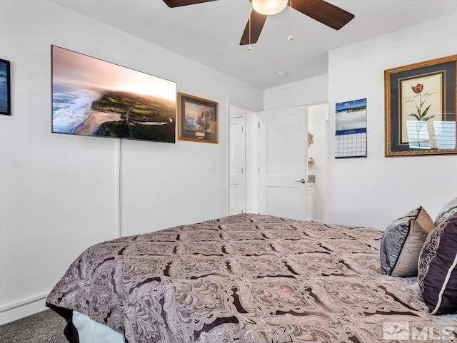 bedroom with ceiling fan and a baseboard heating unit