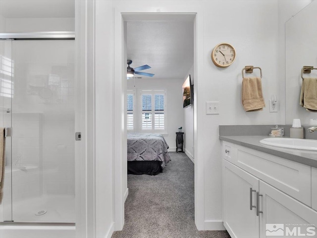 bathroom with ceiling fan, walk in shower, and vanity