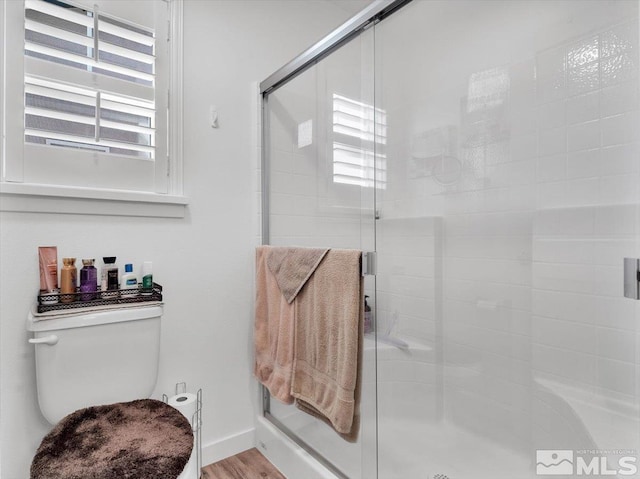 bathroom with hardwood / wood-style floors and a shower with door