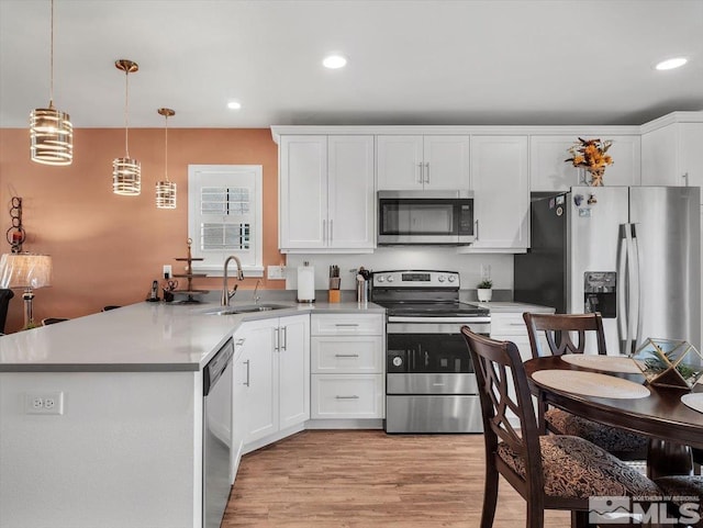 kitchen featuring pendant lighting, white cabinetry, sink, and appliances with stainless steel finishes