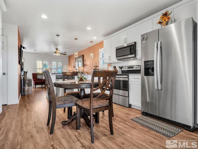 dining room with ceiling fan and light wood-type flooring