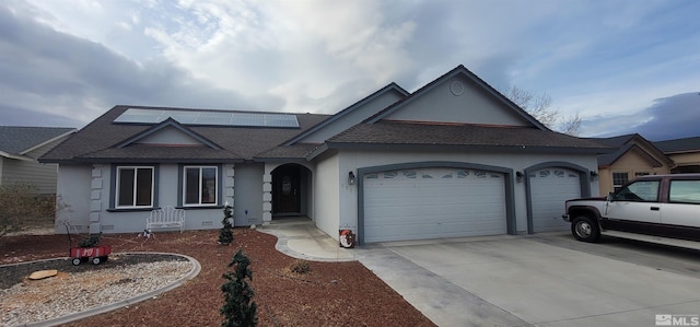 ranch-style home with solar panels and a garage