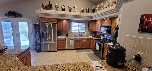 kitchen with french doors, light stone counters, sink, black appliances, and light tile patterned floors