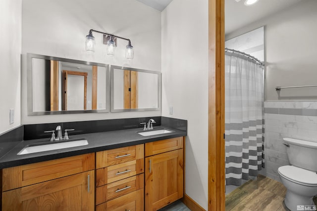 bathroom featuring vanity, toilet, tile walls, curtained shower, and wood-type flooring