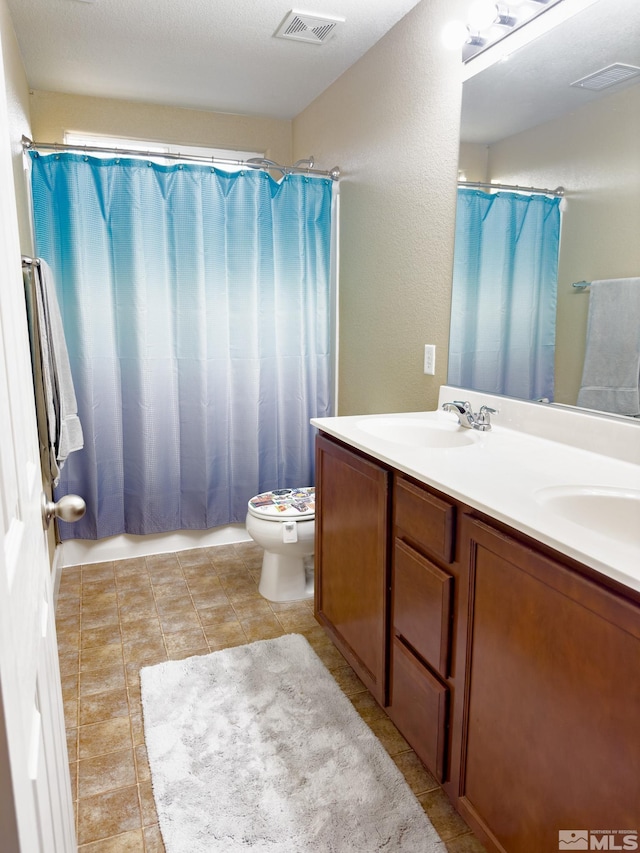 bathroom with vanity, curtained shower, and toilet