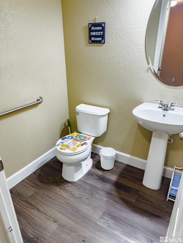 bathroom featuring toilet, wood-type flooring, and sink