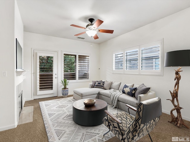 carpeted living room with ceiling fan