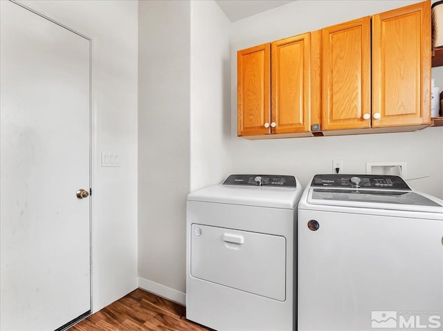 clothes washing area with cabinets, independent washer and dryer, and dark wood-type flooring