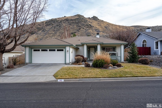 single story home with a mountain view, a garage, and a front lawn