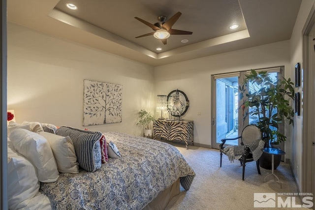 bedroom featuring ceiling fan, a raised ceiling, light carpet, and access to outside