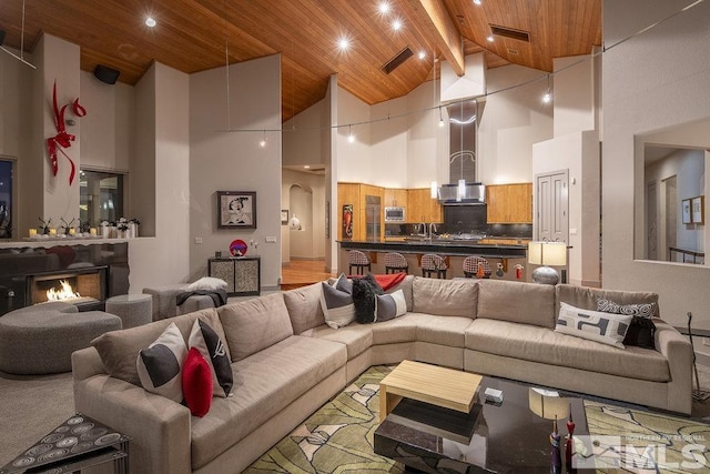 living room with beam ceiling, wood ceiling, and high vaulted ceiling