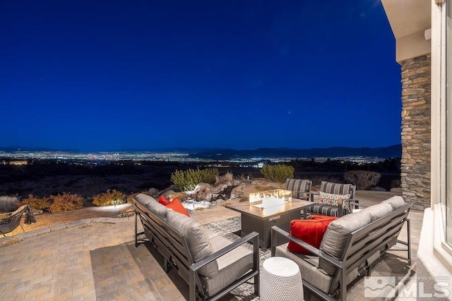 patio at twilight with an outdoor living space with a fire pit