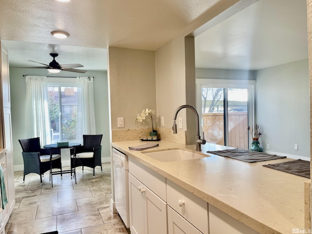 kitchen featuring white cabinetry, a wealth of natural light, dishwasher, and sink