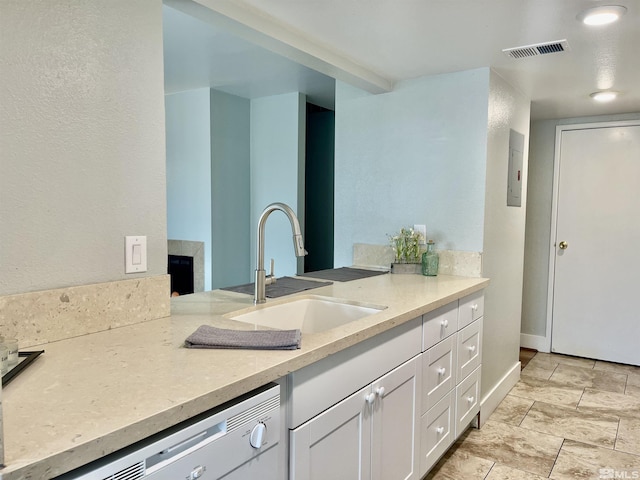 kitchen featuring white cabinetry, sink, light stone countertops, electric panel, and white dishwasher