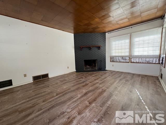 unfurnished living room featuring wood-type flooring, a fireplace, and wood ceiling