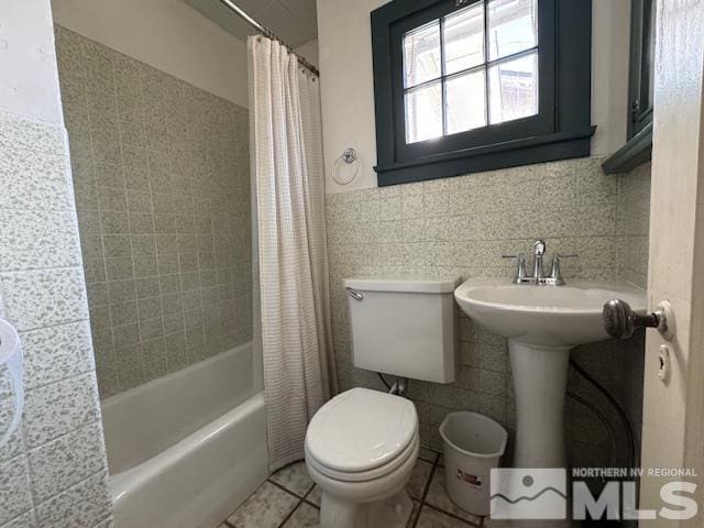 full bathroom with tile patterned floors, shower / bath combo, toilet, and tile walls