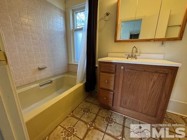 bathroom with tile patterned floors, vanity, and shower / bathtub combination with curtain