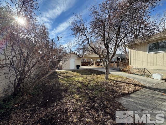 view of yard featuring a storage unit and a carport