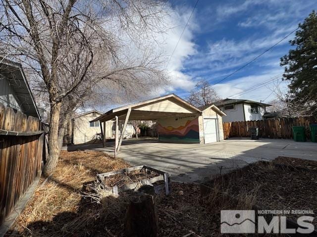 exterior space with a carport, a garage, and an outbuilding