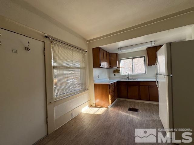 kitchen featuring white refrigerator, sink, and light hardwood / wood-style flooring