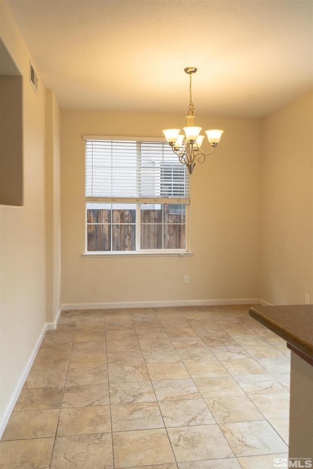 spare room with an inviting chandelier