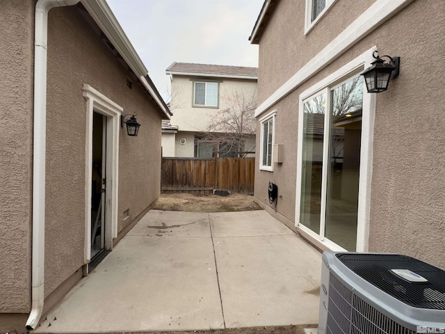 view of side of property with a patio and central AC