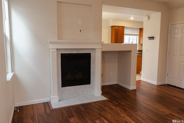 unfurnished living room with a premium fireplace and dark hardwood / wood-style floors