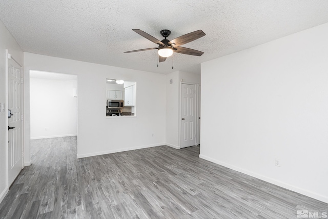 unfurnished room featuring ceiling fan, a textured ceiling, and light hardwood / wood-style flooring