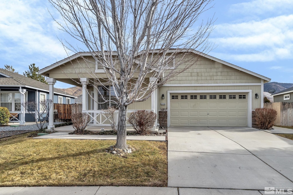 view of front of property featuring a porch, a garage, and a front yard