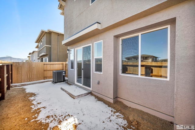 snow covered property with central air condition unit